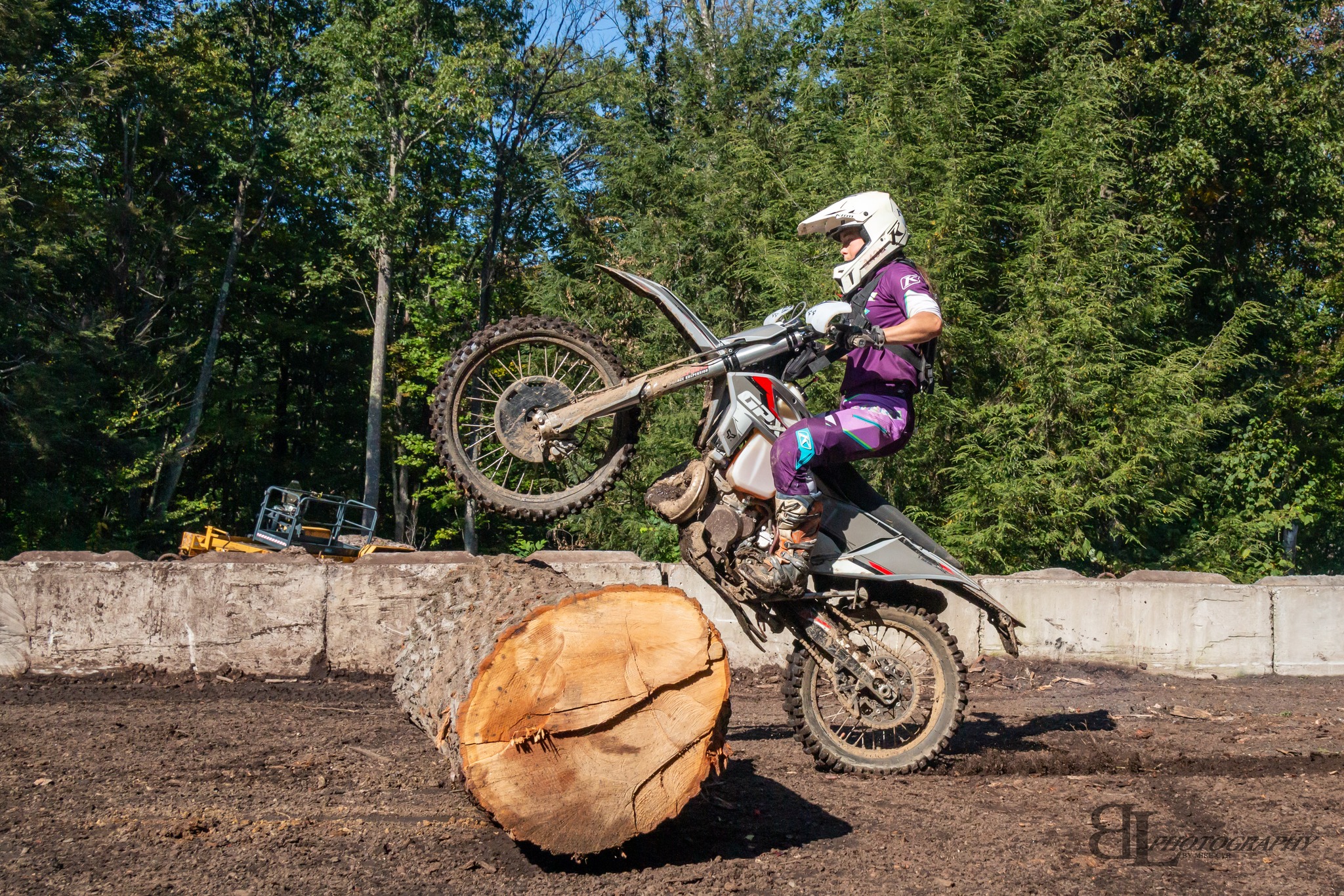 Megs riding over a large log